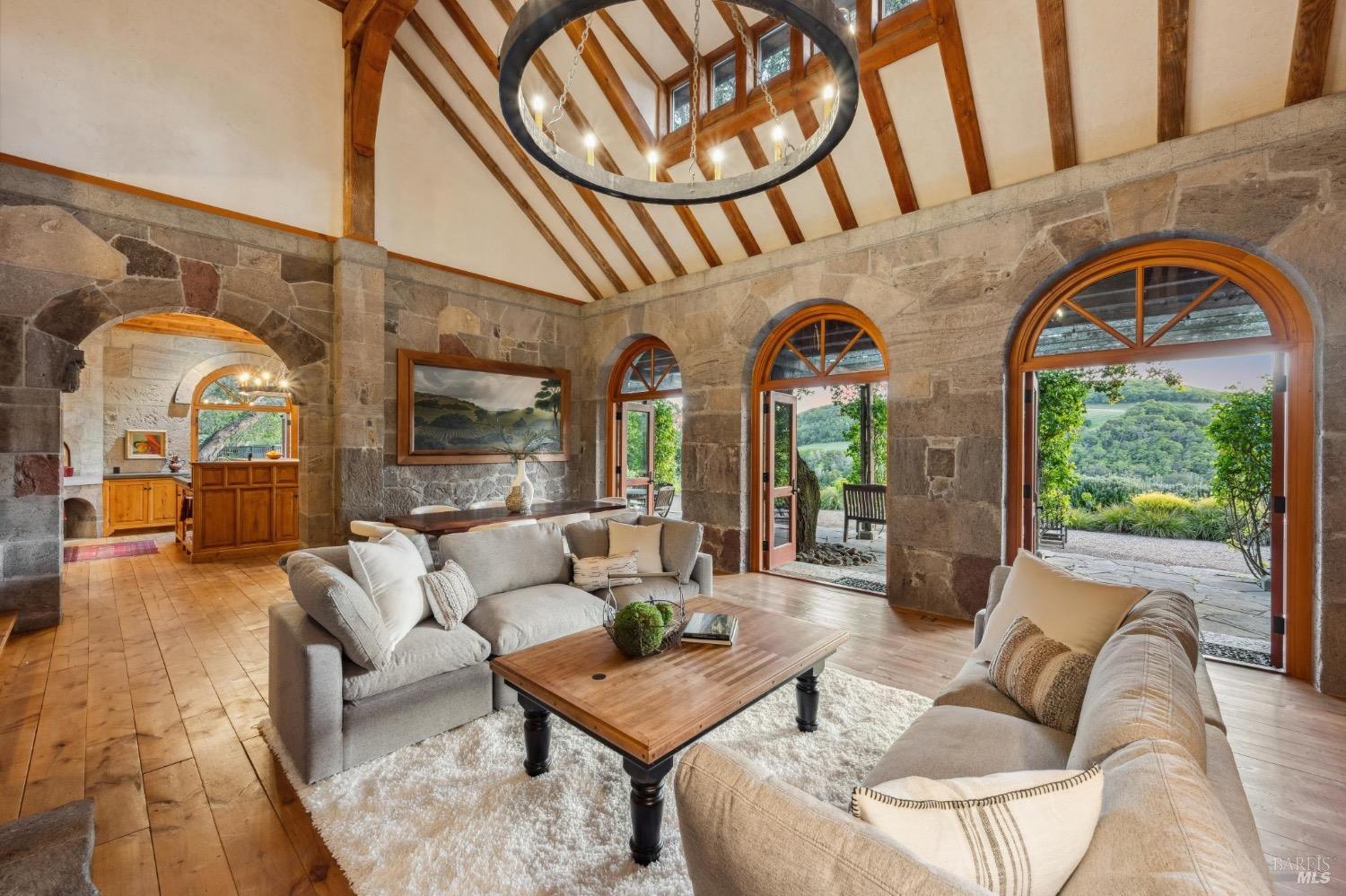 The great room with tall arched doors opened to the valley beyond