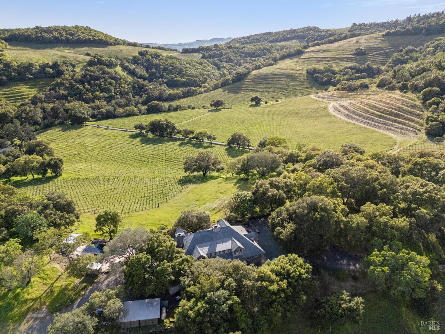 Aerial view over the estate vineyards and the valley, with the Stone House nestled in the oaks